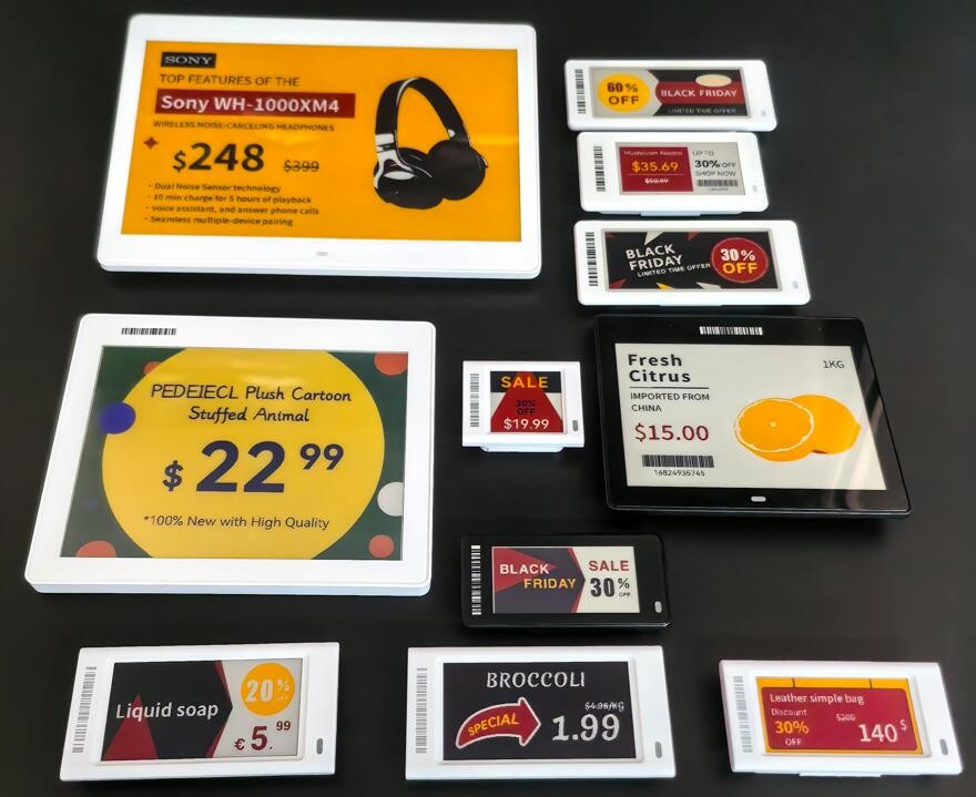 Varias etiquetas electrónicas de diferentes tamaños y colores mostrando precios y promociones en una superficie negra, ejemplos de soluciones de TFA Industries.